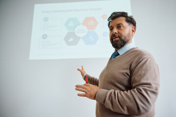Mature teacher talks while giving lecture at university.