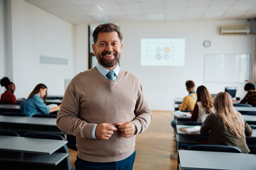 Happy university teacher in classroom looking at camera.