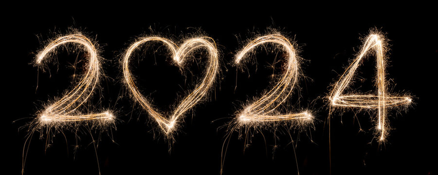 2024 New Year Sparkler Light drawn in numbers and heart shape for happy new year at night time to celebrate special holiday occasion, Christmas party, diwali, independent day or important event