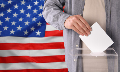 Man putting his vote into ballot box against national flag of United States, closeup. Space for text