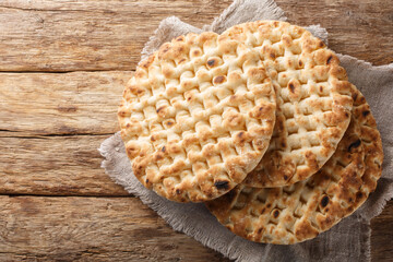 Homemade fresh round pita bread close-up on a wooden table. Horizontal top view from above