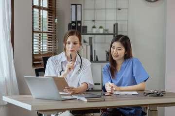 Two female doctor working at desk in clinic office, Teamwork in medicine and healthcare concept.	