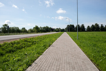 Paved pedestrian path along the highway. Rural area