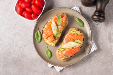 Two tasty open salmon sandwiches with avocado and cucumber. Morning healthy breakfast. Top view.