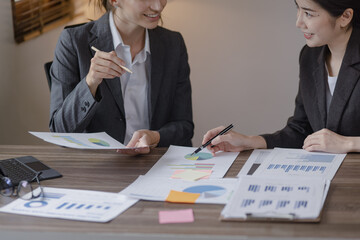 Group of businesswoman team working with analysis financial data visualization tech for marketing strategy, Businesswoman accountant or financial report graph at desk in corporate office.