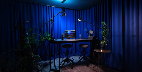 a small minimal podcast studio with black drape walls