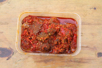 Dendeng Balado or Dendeng Batokok, and is a speciality from Padang, West Sumatra, Indonesia. Made from beef which is thinly cut then dried and fried before adding chillies and other ingredients
