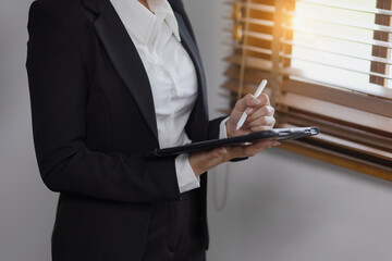 Businesswoman stands with a tablet in hands standing in office. 