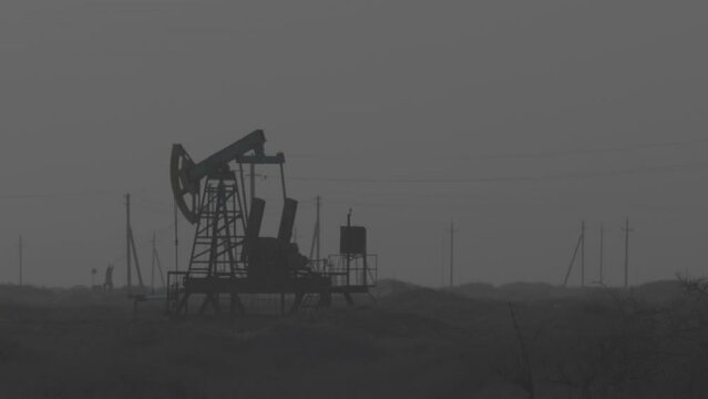 Oil industry, Pumping petroleum Rig in desert. Pump Jack Extracting Crude Oil from a Oil Well. Fossil Fuel Energy. Working oil pump jacks. 4K ProRes 422, ungraded C-LOG 10 bit
