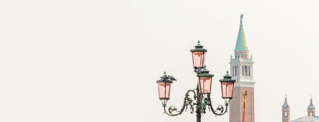 Panoramic view over high Campanile bell tower at San Marco square and old street light at foggy...