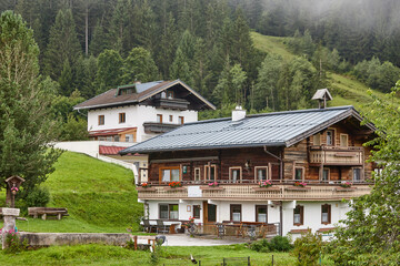 Traditional rural cottages in the forest. Tirol region. Austria