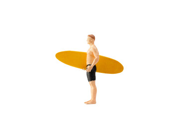 Miniature people man holding a yellow surfboard, isolated on white background with clipping path