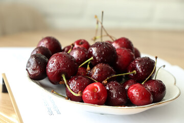 Cherries on a saucer and a book on the table