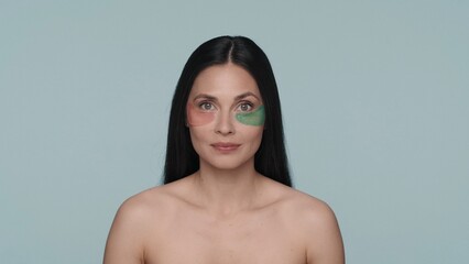 Obraz premium Portrait of a seminude woman with various hyaluronic patches under her eyes on a blue background close up. The concept of beauty, rejuvenation, cosmetology, skin care.