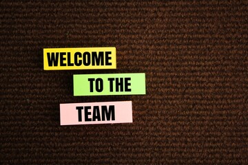 colored paper with the word WELCOME TO THE TEAM. we are hiring. join the group. the concept of teamwork