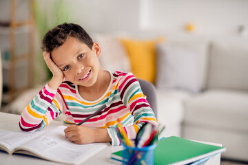 Photo of little young age school boy wear striped stylish casual pullover writing his dictation...