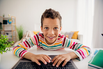 Photo of geek nerd school kid electronics learning using netbook writing homework indoors class room