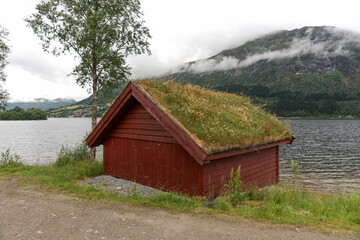 Traditional wooden house with grass on the roof at the fjord. Norway