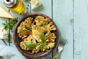 Vegetarian organic food. Baked cauliflower steaks with herbs and spices on a wooden table. Healthy...