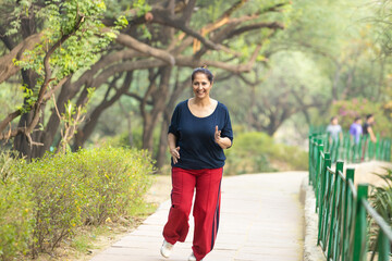 Indian woman doing jogging at park.
