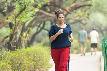 Indian woman doing jogging at park.