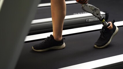 Focus on Disability Prosthetic legs of a person walking on treadmill. 