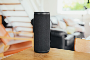 Black portable speaker on a wooden able, modern home 