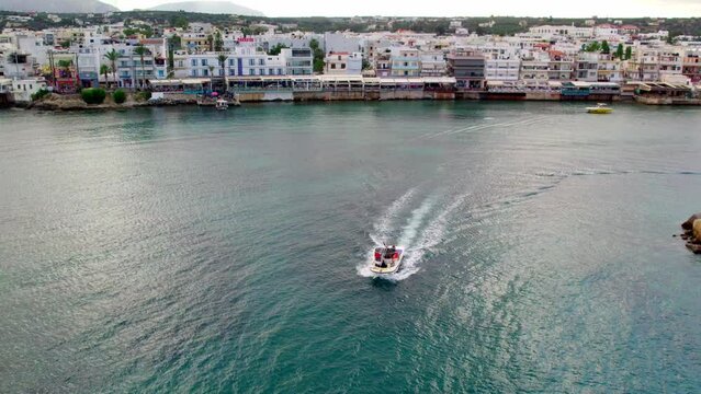 Aerial view of the port in Hersonissos on the Greek island of Crete. The boat floats next to the port in slow motion.