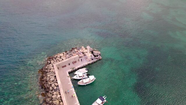 Orbit shot of port of Hersonissos. Drone flying around the bay.
