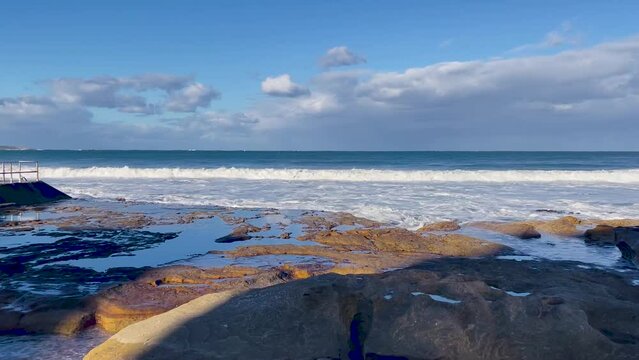 HD Video -Panning close up to the rockpools on the shore and surf movement at North Cronulla Beach in Sydney, NSW, Australia.