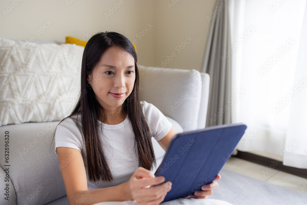 Wall mural woman read on tablet computer at home