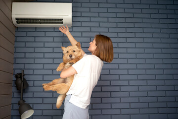 Young woman and her cute dog suffering from extreme heat, record breaking summer heat, trying to...