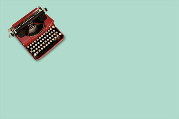 Vintage typewriter on green flat background