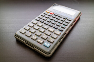 Scientific calculator on black surface background