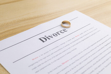 A golden wedding rings above  decree document. Divorce and separation concept. Family  break up or divorce, conflict concept. terminating a marriage or marital union. Divorce laws.