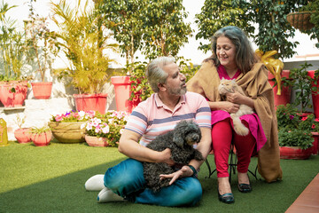 Senior couple playing with dogy puppy and cat. concept of animal love.