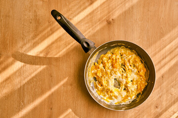 Homemade omelette with cheese on a wooden kitchen table.