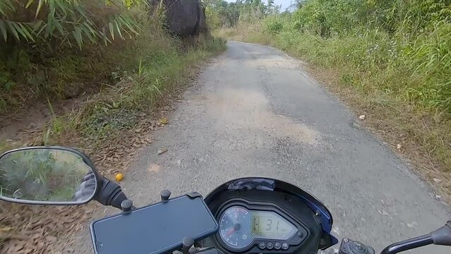 motorcycle rider ridding bike in forests trails at day from flat angle