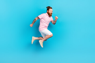Fototapeta premium Full body profile portrait of carefree cheerful man jumping run empty space ad isolated on blue color background