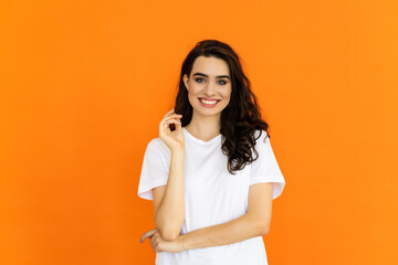 Photo portrait of female smiling with folded hands isolated on bright orange color background