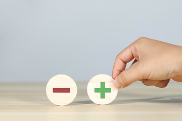 Wooden blocks showing plus and minus signs. The concept of antithesis. Decision making. Positive or negative business choice. Analysis of advantages and disadvantages Comparison	
