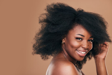 Portrait, hair care and black woman with smile, beauty and wellness on a brown studio background. Mockup space, person and model with texture, afro and natural with aesthetic, makeup and cosmetics