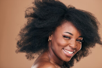 Portrait, hair care and black woman with beauty, afro and smile on a brown studio background....