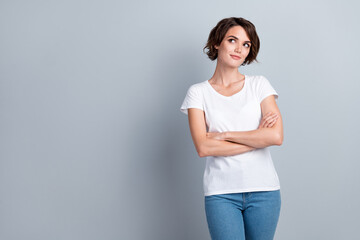 Photo of confident dreamy woman dressed white t-shirt arms crossed looking empty space isolated...