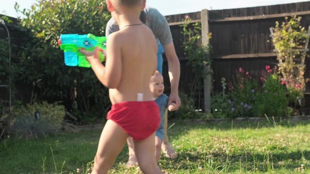 baby takes first steps in grass. Dady Father walks with son in nature kid dream concept. baby takes first steps with mom. mom and little son feet baby close-up happy family Hot Summer Day. Fatherhood