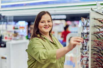 Portrait of an overweight woman looking for eyeglasses in an optic store.