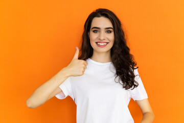 Like portrait. Approval concept. Confident woman with thumb up. Isolated on orange free space.