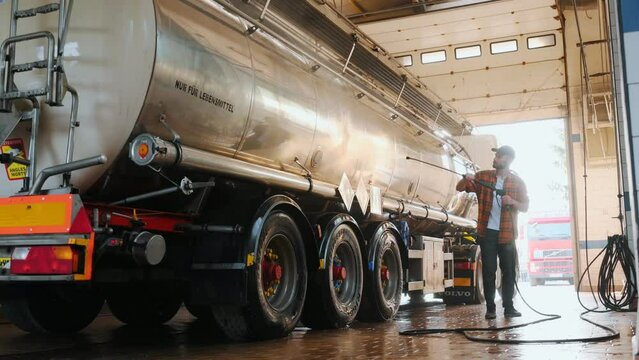Washing the vehicle. Young truck driver in casual clothes.