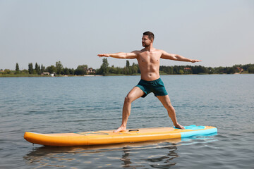 Man practicing yoga on SUP board on river