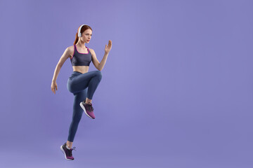 Fototapeta na wymiar Woman in sportswear running on violet background, space for text